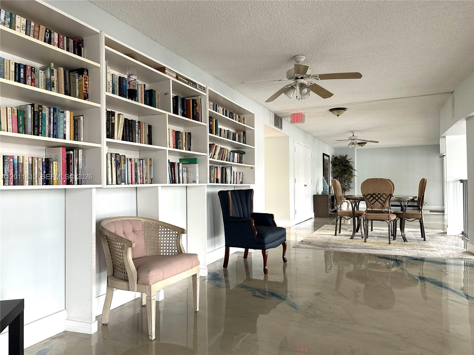 9370 Southwest 8th Street, Unit 107 Boca Raton, FL 33428 - Photo 17 of 17 a living room with furniture and a book shelf