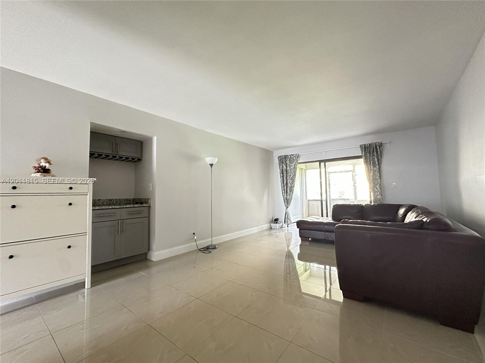 9370 Southwest 8th Street, Unit 107 Boca Raton, FL 33428 - Photo 2 of 17 a room with a window and dresser