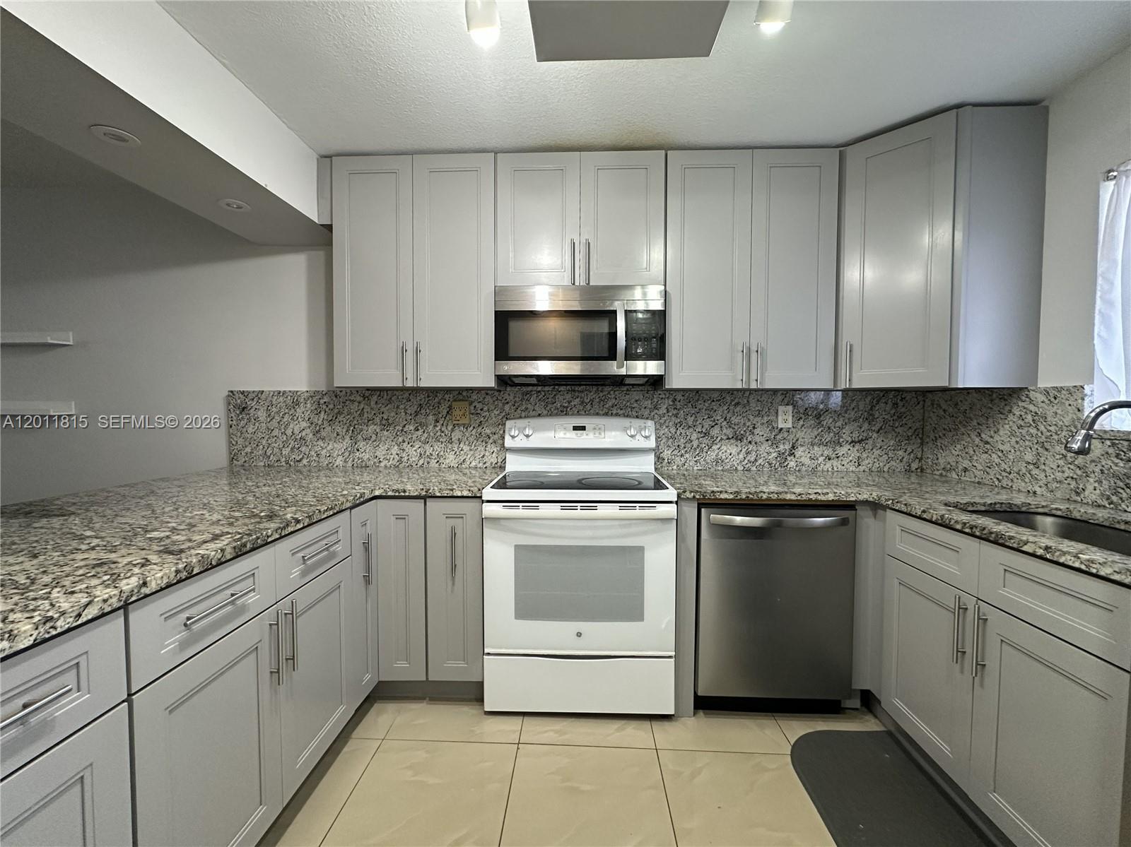 9370 Southwest 8th Street, Unit 107 Boca Raton, FL 33428 - Photo 10 of 17 a kitchen with cabinets appliances and a sink