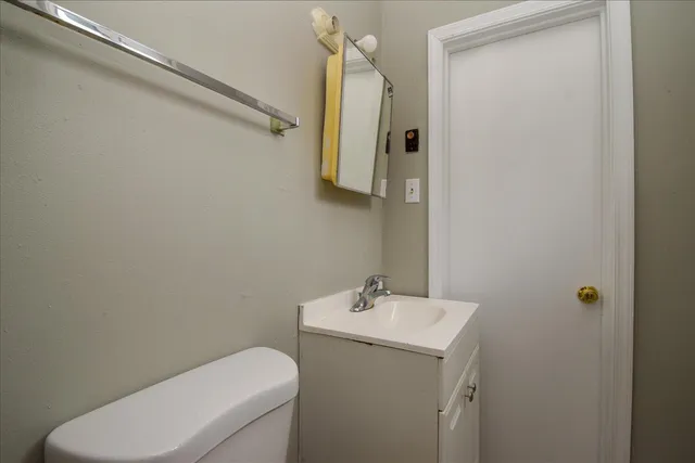 a bathroom with a toilet sink and mirror