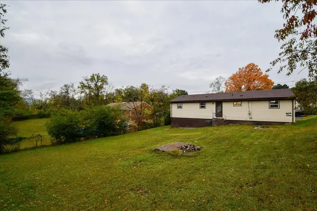 a view of a house with a big yard and large trees