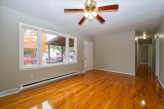 an empty room with windows and fan