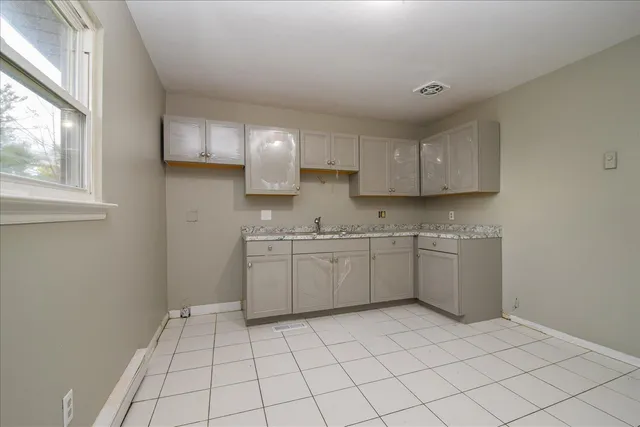 a kitchen with a sink window and cabinets