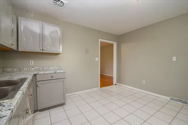 a kitchen with a stove cabinets and utility room