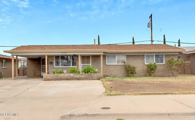 a front view of a house with a yard and potted plants