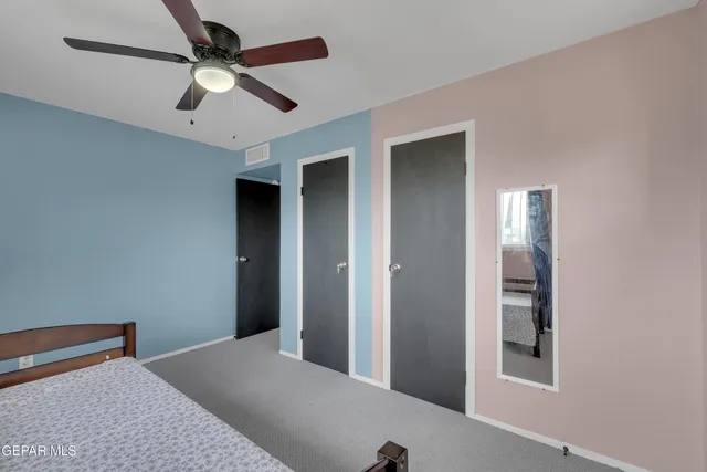 a bedroom with a bed and a ceiling fan