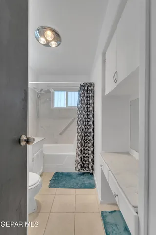 a bathroom with a granite countertop bathtub and shower