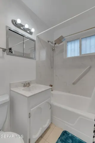 a bathroom with a sink a toilet a mirror and shower