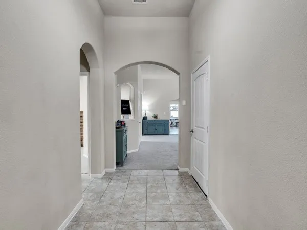 a view of a hallway with a livingroom and a bathroom with sink