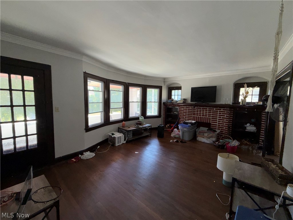 18017 Olympia Road Cleveland, OH 44112 - Photo 13 of 34 Hardwood flooring, brick fireplace surround, built-in shelving, bay windows, and crown molding