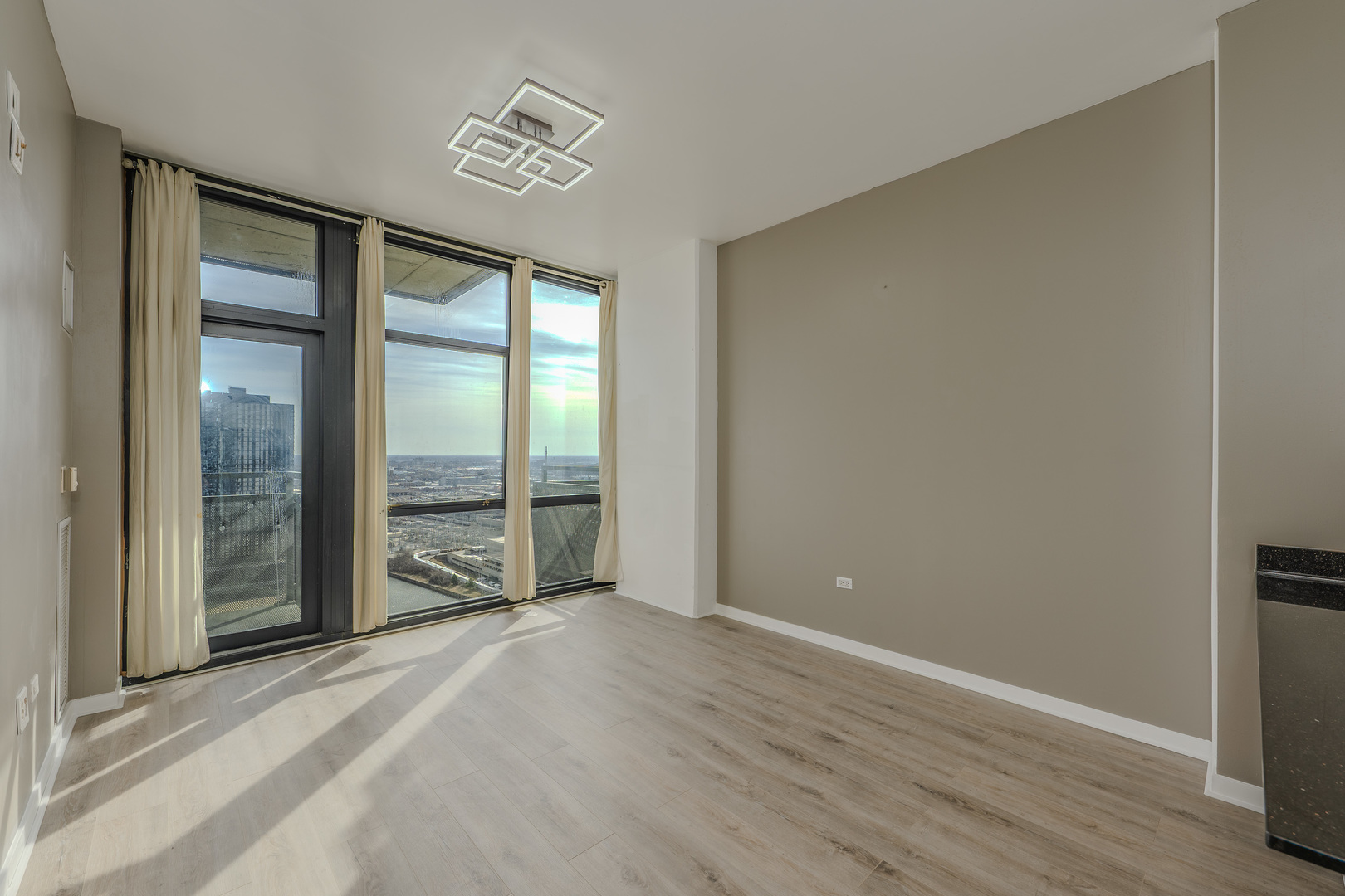 235 West Van Buren Street, Unit 3105 Chicago, IL 60607 - Photo 5 of 29 an empty room with wooden floor and windows