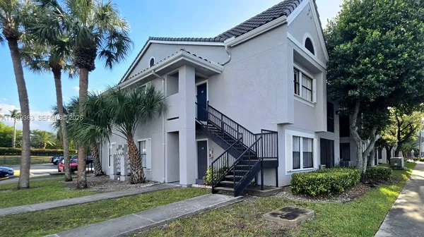 a view of a house with backyard and trees