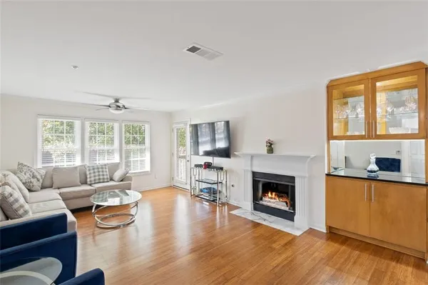 a living room with furniture a fireplace a flat screen tv and windows