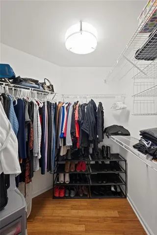 a view of walk in closet with clothes and shoes