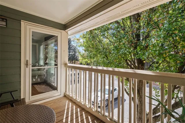 a view of a balcony with a floor to ceiling window and wooden floor