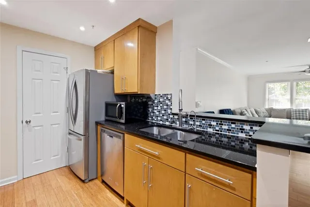 a kitchen with stainless steel appliances granite countertop a refrigerator and a sink
