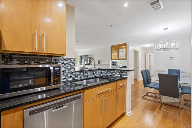 a kitchen with stainless steel appliances granite countertop a stove a sink and a microwave