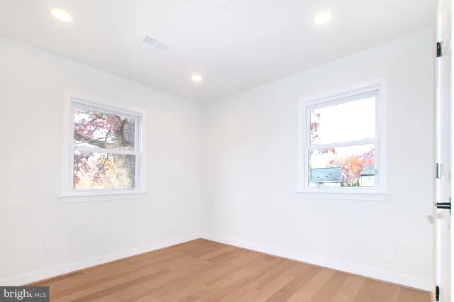 an empty room with wooden floor and window