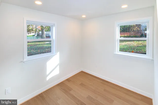 an empty room with wooden floor and window
