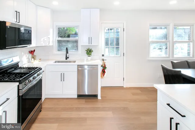 a kitchen with stainless steel appliances a stove a sink and a microwave