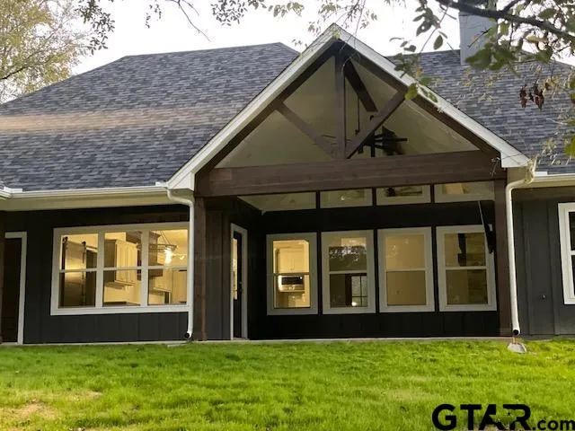 a view of a brick house with a big yard and large trees