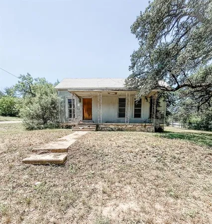 a front view of a house with a yard and potted plants