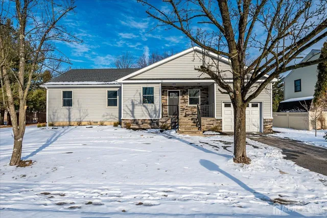 a view of a white house with a large tree