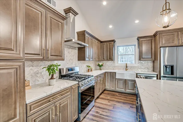 a kitchen with stainless steel appliances granite countertop a stove top oven a sink dishwasher a dining table and chairs with wooden floor