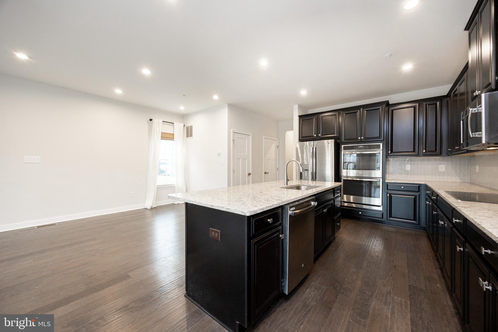 131 Mulberry Drive Malvern, PA 19355 - Photo 6 of 37 a kitchen with stainless steel appliances granite countertop a stove a sink and a refrigerator