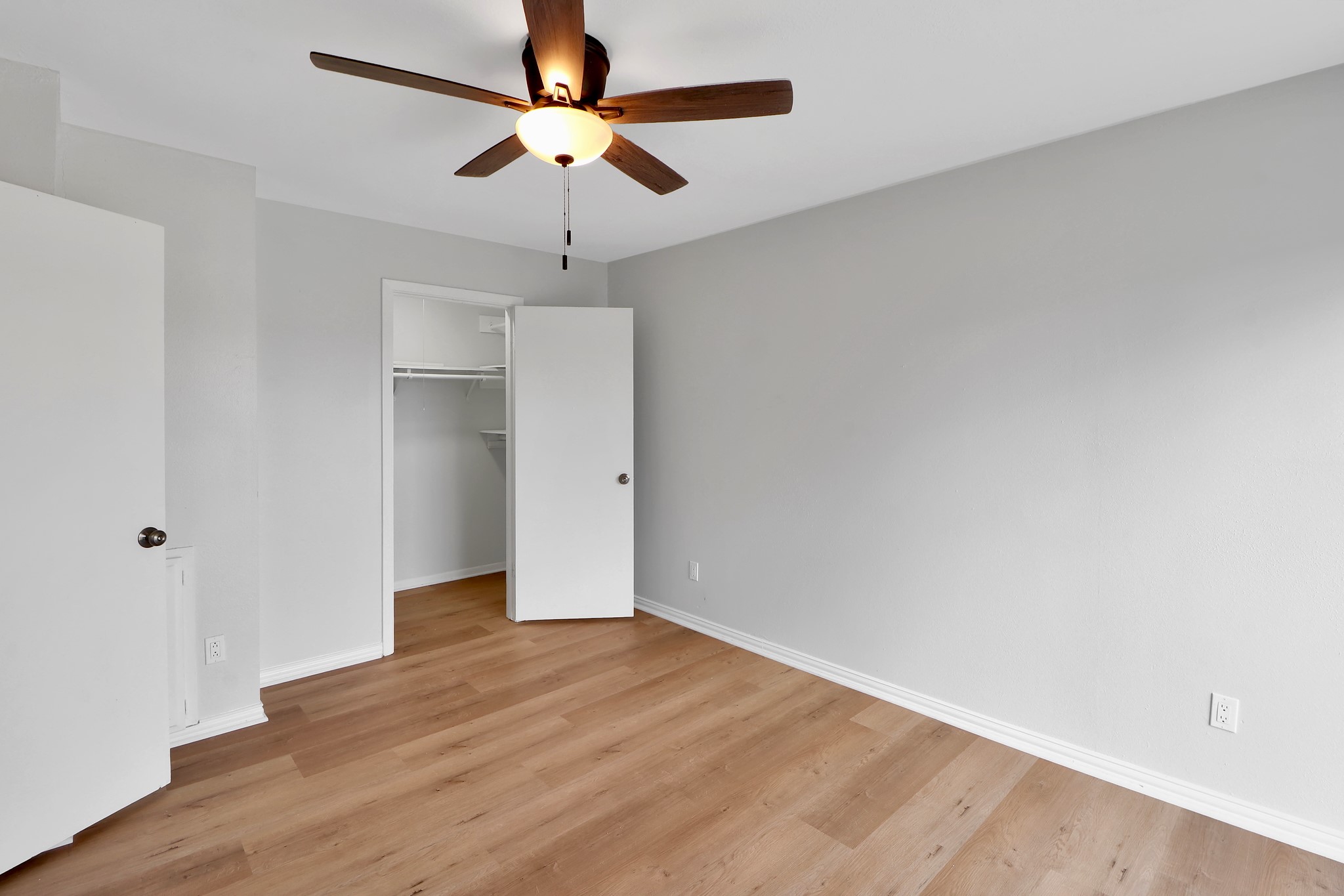 7047 Bissonnet Street, Unit 117 Houston, TX 77074 - Photo 11 of 17 an empty room with wooden floor ceiling fan and window