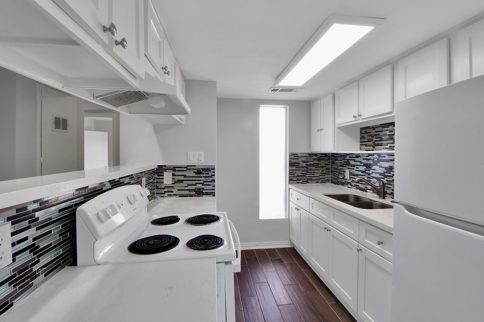 7047 Bissonnet Street, Unit 117 Houston, TX 77074 - Photo 7 of 17 a kitchen with white cabinets and white appliances
