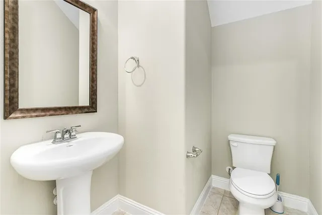 an empty room with wooden floor chandelier and windows