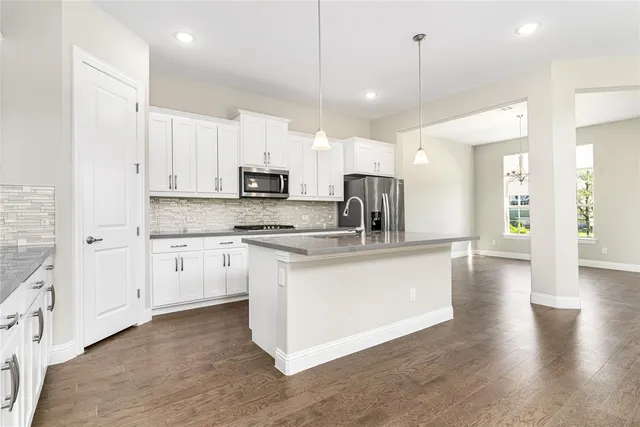 a view of staircase and kitchen with wooden floor and kitchen view
