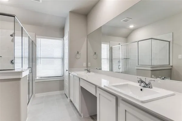 a bathroom with a sink double vanity granite tub shower and a mirror
