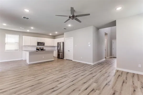 a view of kitchen with refrigerator microwave and stove