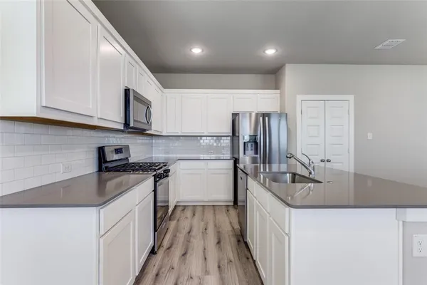 a kitchen with stainless steel appliances granite countertop a sink stove and refrigerator