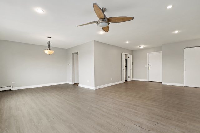 4700 Old Orchard Road, Unit 403 Skokie, IL 60076 - Photo 5 of 21 an empty room with wooden floor ceiling fan and windows