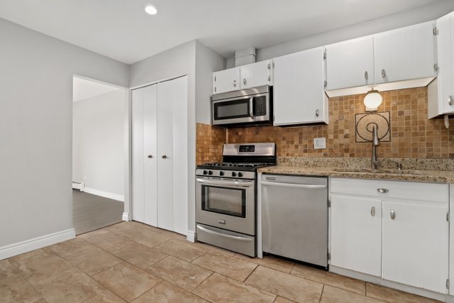 4700 Old Orchard Road, Unit 403 Skokie, IL 60076 - Photo 10 of 21 a kitchen with granite countertop white cabinets and stainless steel appliances
