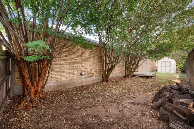 a view of a small house with a small yard and wooden fence