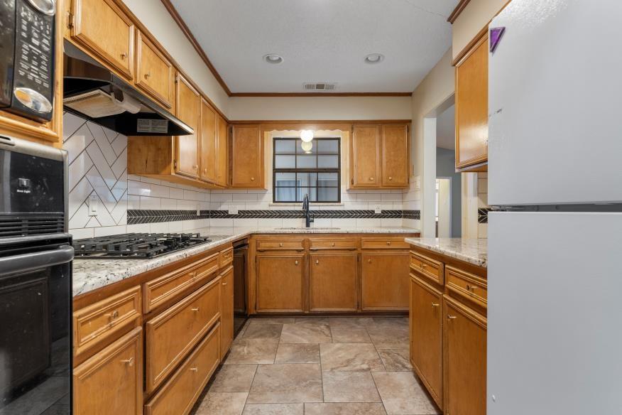 827 Fort Gates Waco, TX 76708 - Photo 8 of 25 a kitchen with stainless steel appliances granite countertop a sink and a stove