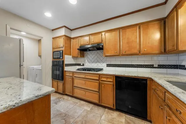 a kitchen with stainless steel appliances granite countertop sink stove and refrigerator