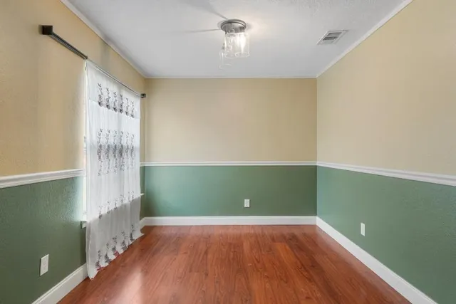 a view of room with window and wooden floor