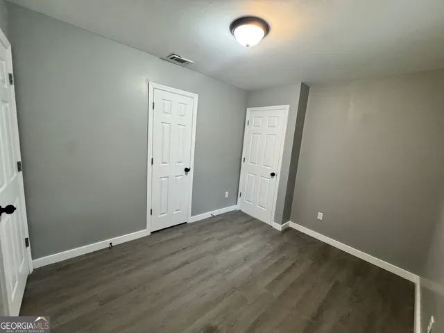 an empty room with wooden floor and closet