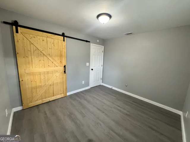 an empty room with wooden floor and door