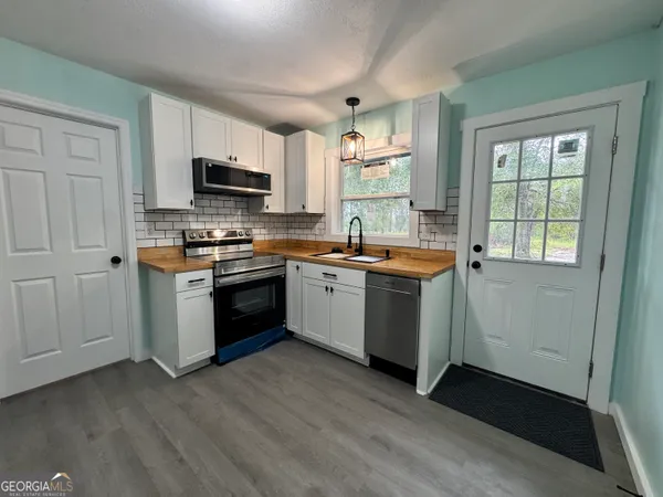 a kitchen with a sink stove top oven and microwave
