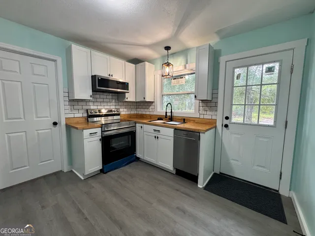 a kitchen with a sink stove top oven and microwave