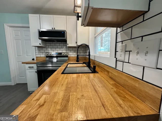 a kitchen with stainless steel appliances a stove a sink and a microwave