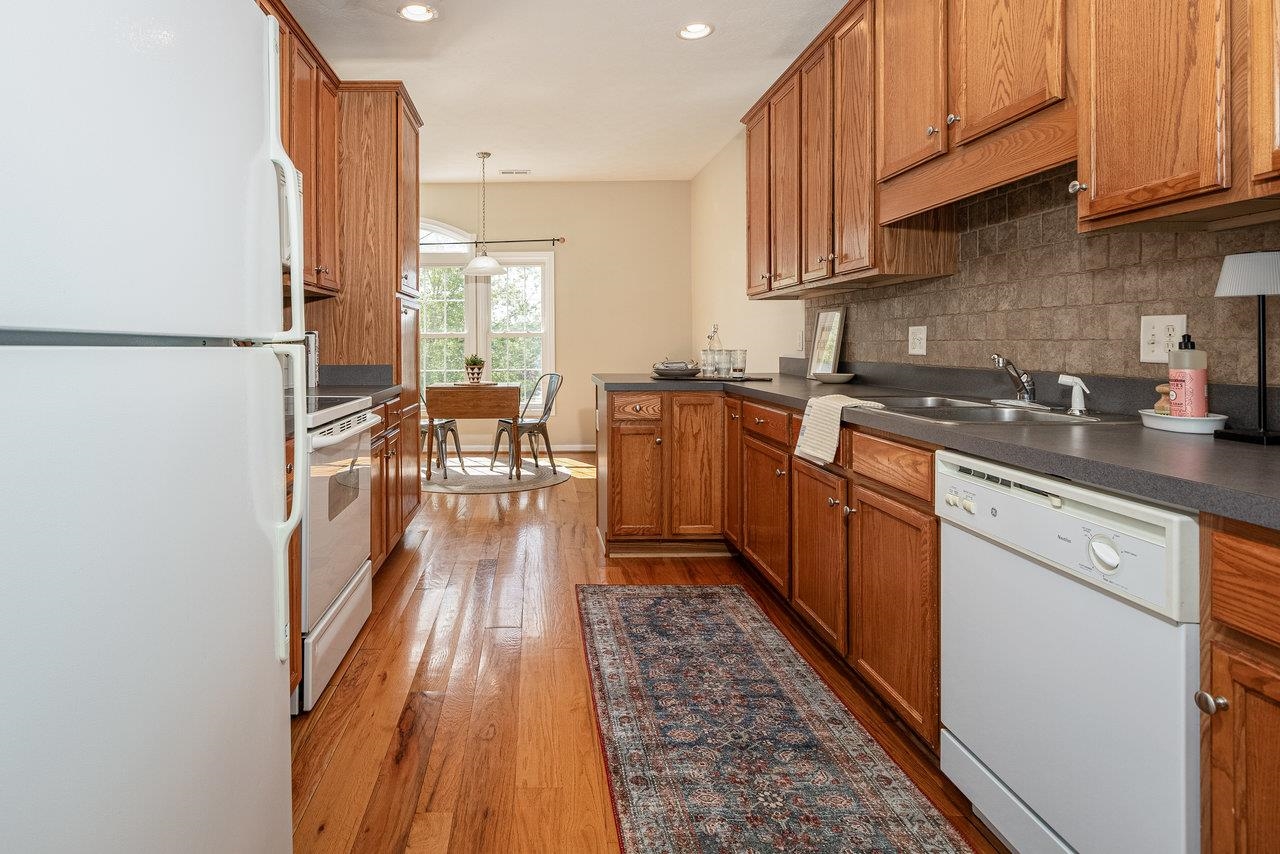 1398 Verdant Spring Lane Harrisonburg, VA 22801 - Photo 11 of 43 a kitchen with stainless steel appliances granite countertop a refrigerator a sink dishwasher a stove and white countertops with wooden floor