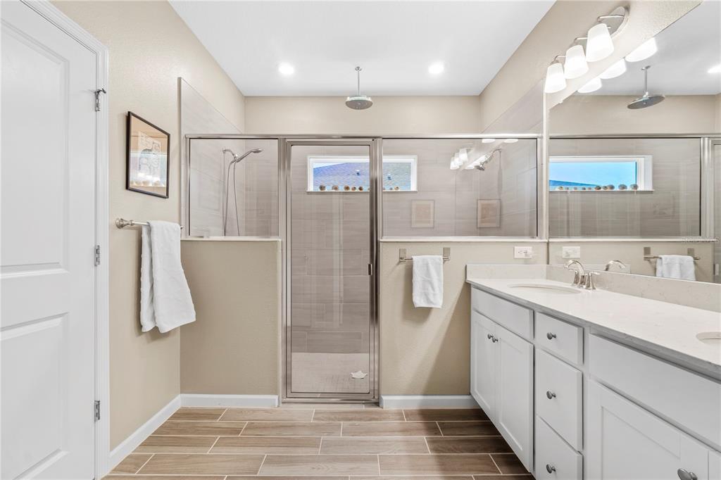 7381 Southwest 78th Terrace Ocala, FL 34474 - Photo 22 of 47 a spacious bathroom with a double vanity sink a mirror and shower