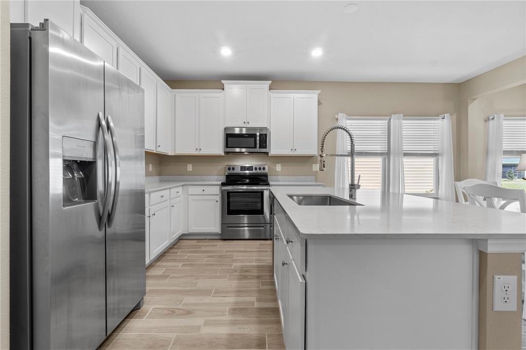 7381 Southwest 78th Terrace Ocala, FL 34474 - Photo 7 of 47 a kitchen with stainless steel appliances granite countertop a refrigerator a sink a stove and white cabinets